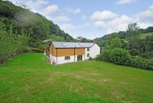 a house in a field with a green yard at Exmoor Farmhouse in Bampton