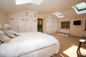 a bedroom with a large white bed and skylights at Exmoor Farmhouse in Bampton