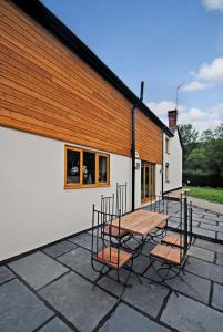 a patio with a table and chairs next to a building at Exmoor Farmhouse in Bampton +4 photos