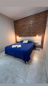 a bedroom with a blue bed with towels on it at Apart La Ideal in Villa Cura Brochero