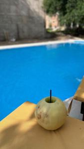 an apple sitting on a table next to a pool at Apart La Ideal in Villa Cura Brochero