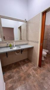 a bathroom with a sink and a mirror and a toilet at Apart La Ideal in Villa Cura Brochero