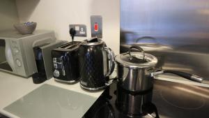 two pots sitting on a counter next to a microwave at Conveniently Located, 2 Bedroom Modern Apartment in Dublin