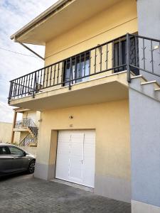 ein Haus mit einem weißen Garagentor und einem Balkon in der Unterkunft casa da serra in Boa Viagem