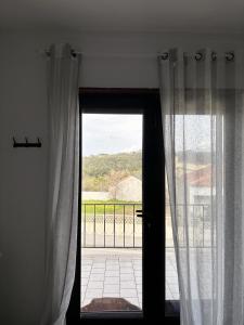 eine Tür mit Vorhängen und Blick auf einen Balkon in der Unterkunft casa da serra in Boa Viagem