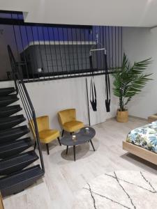 a room with two chairs and a table and a staircase at Love Room in Bassan +3 photos