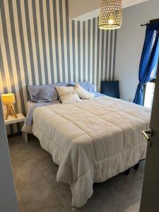 a bedroom with a large bed with a striped wall at Reina Victoria in San Juan