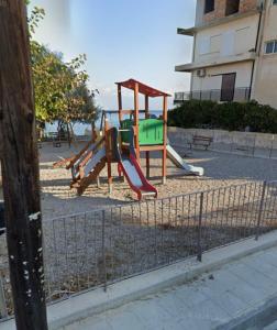 a playground with a slide in front of a building at Lemon tree Gr in Xylokastro