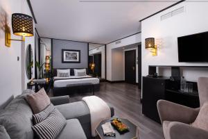 a hotel room with a bed and a couch at Athenian Riviera Hotel& Suites in Athens