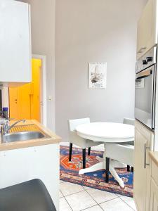 a kitchen with a white table and a table and chairs at Manneken View in Brussels +12 photos