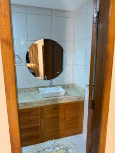 a bathroom with a sink and a mirror at Casa centro in Porto Seguro +13 photos