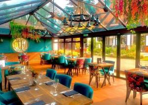 a restaurant with tables and chairs in a room at The Stanwick Hotel in Stanwick