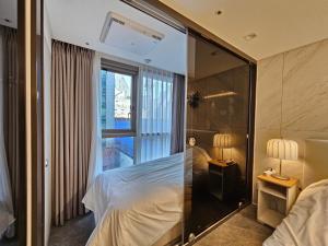 a hotel room with a bed and a glass wall at Cookie House in Seoul