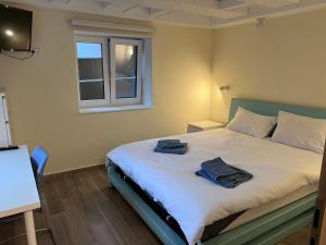a bedroom with a bed with two towels on it at The LODGE, separate apartment in a vila, with floor heating, groundfloor in Sinaia
