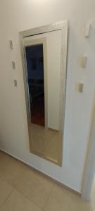 a mirror on a white wall in a room at Apartment Lovor in Krk