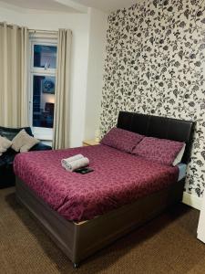 1 dormitorio con 1 cama con edredón morado en Aindale Hotel Blackpool, en Blackpool 10 fotos más