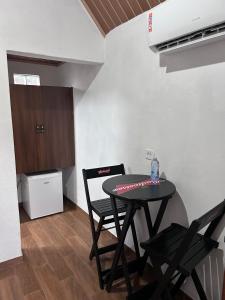 a dining room with a table and two chairs at Pousada Turmalina in Bueno Brandão