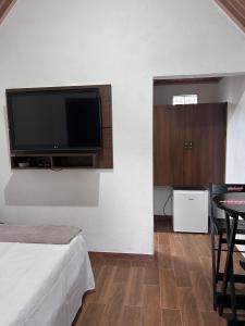 a room with a flat screen tv on a wall at Pousada Turmalina in Bueno Brandão