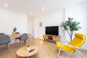 プエルト・デ・ラ・クルスにあるFamily Friendly Apartament Puerto de la Cruz Summa Hausのリビングルーム(黄色い椅子、テレビ付)