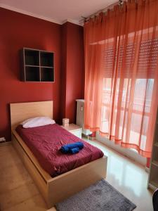 una camera con letto e pareti rosse di Guesthouse - Metro M1 Sesto Rondò a Sesto San Giovanni
