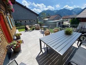 a patio with a table and chairs and mountains at Chalet & Almhostel Alpenperle - Selbstversorger Unterkunft in Tannheim