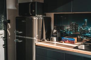a kitchen with a refrigerator and a view of a city at Apartman FRAN in Križevci
