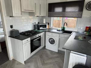 a kitchen with white cabinets and a stove top oven at Aspen Lodge in Morpeth