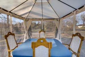 une tente avec une table bleue et deux chaises dans l'établissement Less Than 3 Mi to Dtwn Modern Cottage in Greenville!, à Greenville