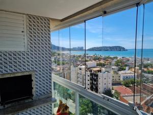 a room with a fireplace and a view of the ocean at A melhor vista da Enseada Guarujá! in Guarujá
