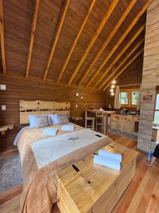 a bedroom with a large bed in a wooden room at Paradouro da Serra Cabanas in Cambara do Sul