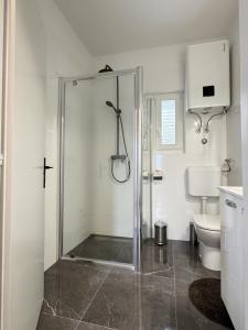 a bathroom with a shower and a toilet at ANKA - apartment by the sea in Kali +23 photos