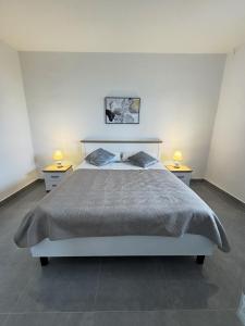 a bedroom with a bed with two nightstands and two lamps at ANKA - apartment by the sea in Kali