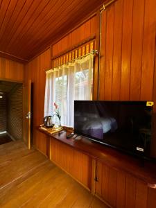 a living room with a large television and a window at Bait Lino in Rantepao