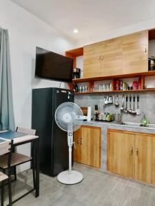 a kitchen with a black refrigerator and a fan at Abelarde Casita at Bata in Bacolod +4 photos