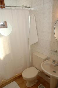 een witte badkamer met een toilet en een wastafel bij Hotel Porto Alegre in Porto Alegre