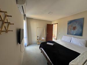 una camera da letto con un letto grande e una televisione di Rota Ecologica dos Milagres-PATACHO Condominio PORTO GRANDE a Pôrto de Pedras Altre 17 foto