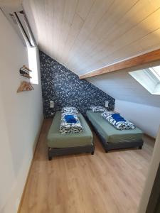 two beds in a room with a attic at Maison avec terrasse le tilleul in Héricourt