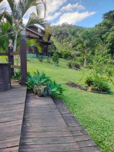 a wooden path leading to a house with a garden at Sitio Vida in Aguas Mornas