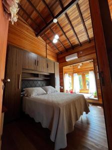 a bedroom with a bed in a room with wooden walls at Sitio Vida in Aguas Mornas