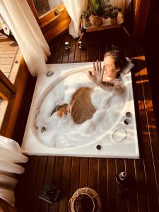 a woman in a bathtub with a monkey in it at Sitio Vida in Aguas Mornas