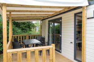 a patio with a table and chairs on a deck at Camping Abijune d'Étretat in Le Tilleul