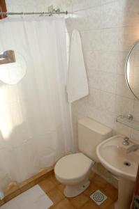 een witte badkamer met een toilet en een wastafel bij Hotel Porto Alegre in Porto Alegre