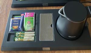 a black tray with a cup and snacks and a mug at Spatzennester-Vogelsberger Hof in Grebenhain