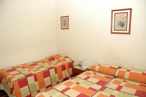 een kamer met 2 bedden en een telefoon. bij Hotel Porto Alegre in Porto Alegre