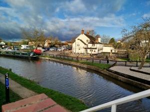 a river with a house and a boat on it at River Cottage in Derby