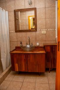 un baño con lavabo y espejo en Shalom Hospedaje, en Tandil