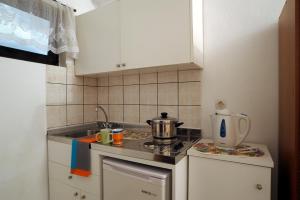 a small kitchen with a stove and a sink at Ferienhaus Elena in Agios Georgios