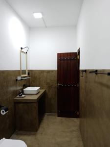 a bathroom with a sink and a toilet and a mirror at The wild culture in Sigiriya +39 photos