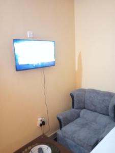 Una sala de estar con un sofá y un televisor de pantalla plana. en Watamu tamu, en Watamu