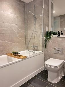 a bathroom with a shower and a toilet and a tub at 2Bed 2Bath Private Balcony, Relaxing Waterfront View Apt, Parking FREE WiFi 10mins Media City, Salford Quays, Old Trafford, City Centre in Manchester